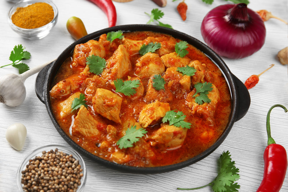 chickencurrywithvegetablesonwoodenbackground